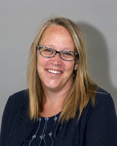 A portrait of Stephanie Mulligan from the chest up. she has blonde hair and is wearing a navy blue top.