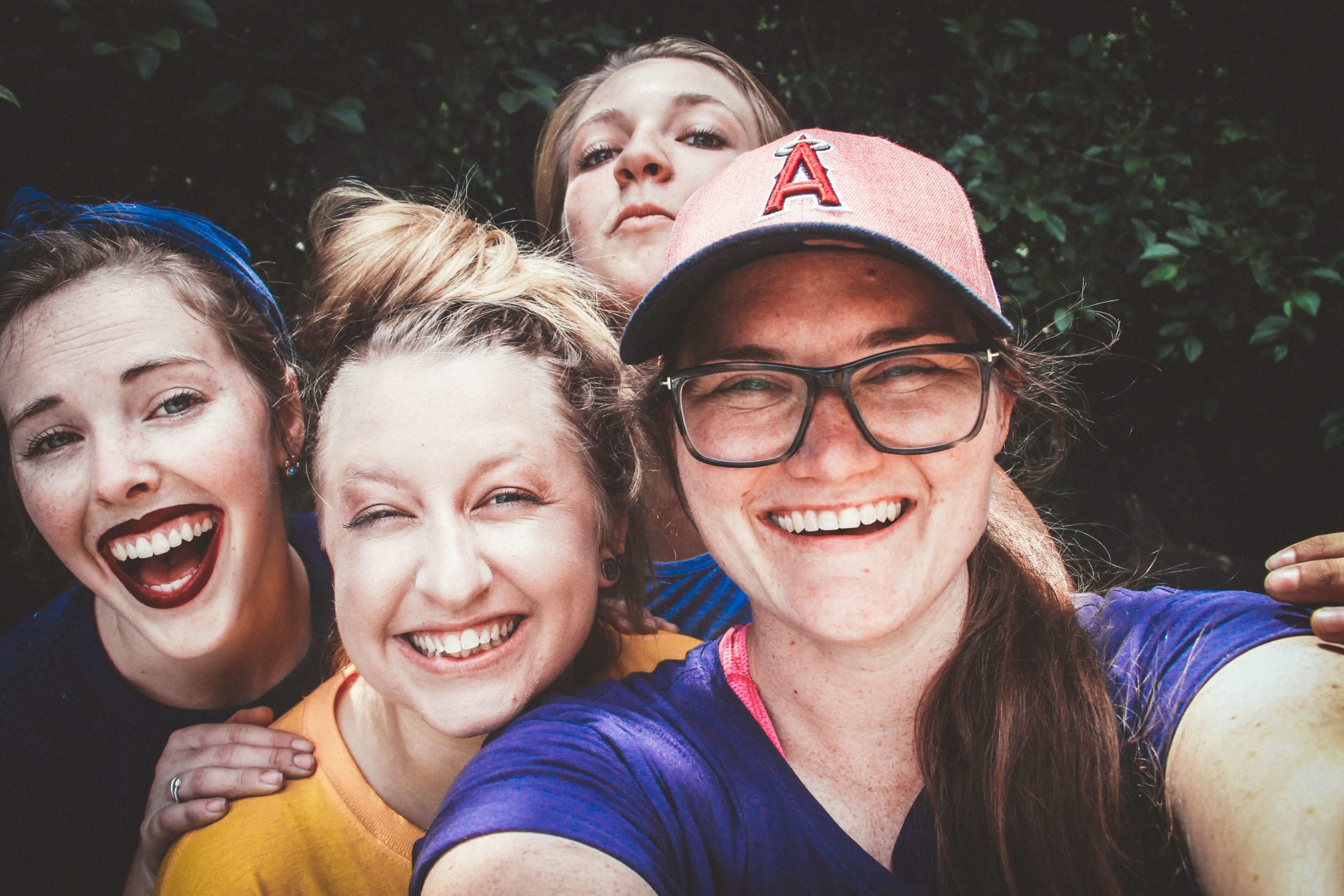 4 women taking a slefie outdoors. They are all smiling and laughing