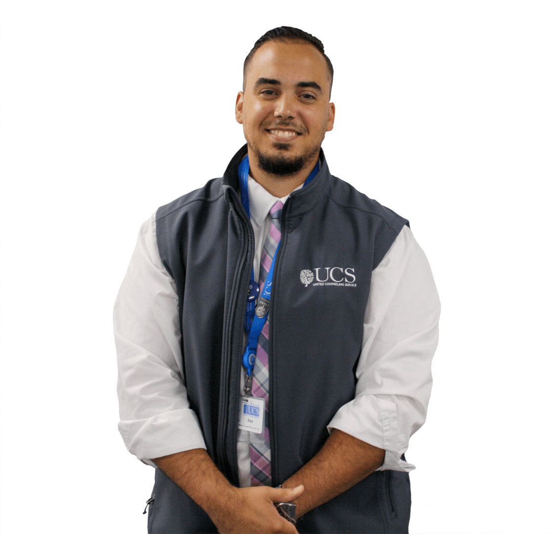 A man wearing a gray UCS vest smiles while looking at the camera.