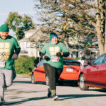 Two adults wearing Ninja Turtles t-shirts run.