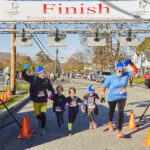 A group of runners cheers at the finish line.