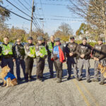 A group of police officers and dogs pose for a photo.