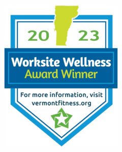 blue outlined badge graphic that reads: 2023 worksite wellness award winner for more information visit vermontfitness.org. 2023 has a green graphic of the outline of Vermont and there is a darker green star graphic at the bottom of the whole image.