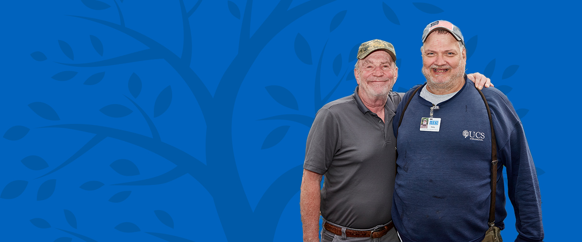 two men smiling on a blue background