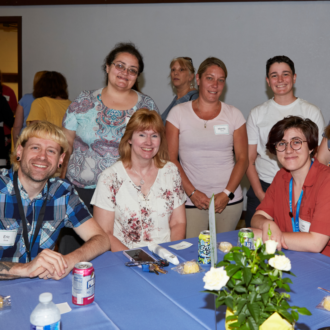 UCS employees sit around a table smiling