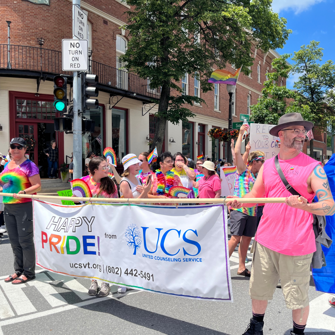 UCS employees participating in the Bennington Pride parade on Main Street in Bennington, VT holding a banner that says "Happy pride from UCS"