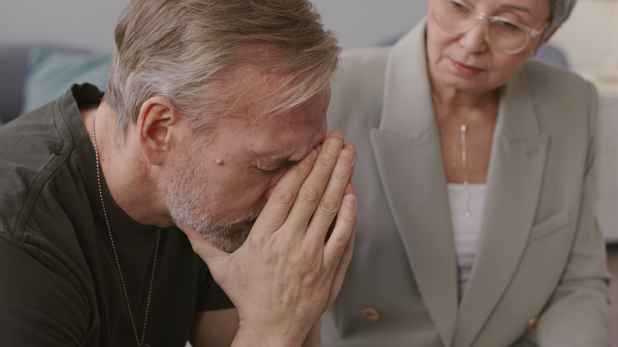 Caucasian military man crying while older lady comforts him