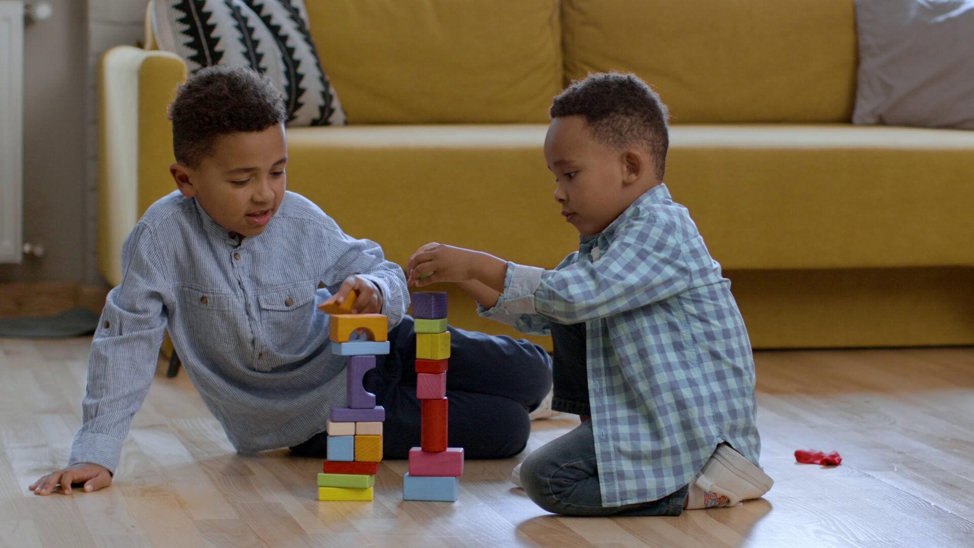 Two black children playing together with blocks