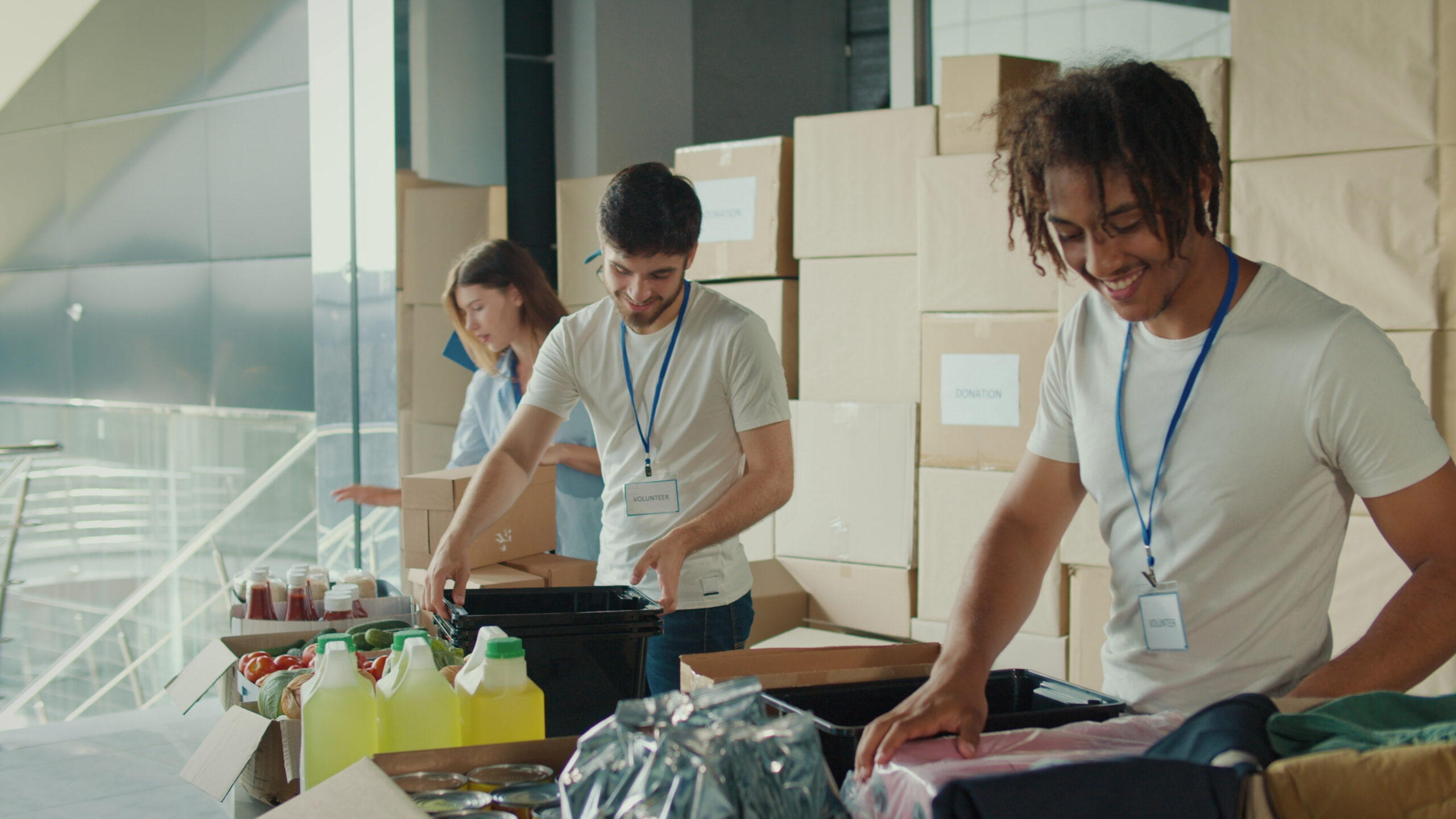 Three young volunteers patching food and smiling